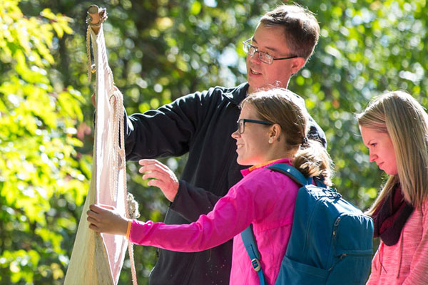Jon Oliver and students looking at ticks