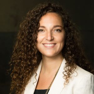 Mariana Tuttle in a white jacket and black shirt smiling.