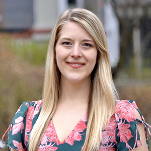 Caroline West smiling while standing outside.