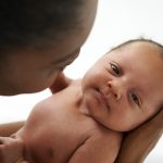 Close up of mother cradling newborn son