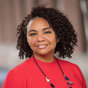 Jaime Slaughter-Acey smiling in a red shirt.