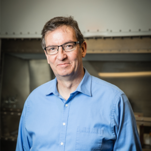Peter Raynor wearing a blue shirt and standing inside a lab.