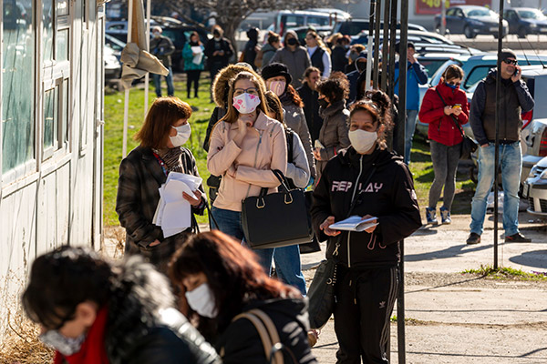 people in masks waiting in line