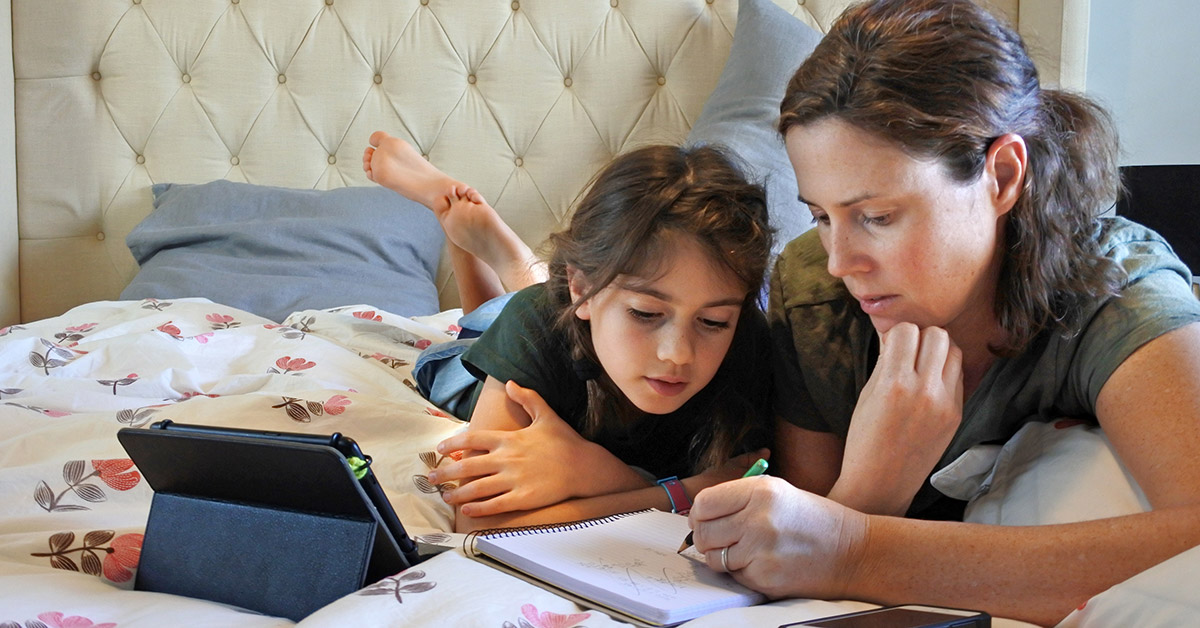 A mother helps her child with remote learning.