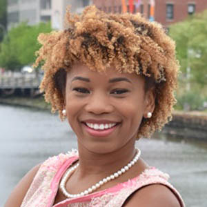 Shekinah Fashaw-Walters smiling in front of an urban river.