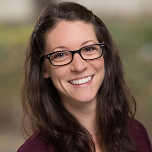 Julia Interrante wearing glasses and smiling.