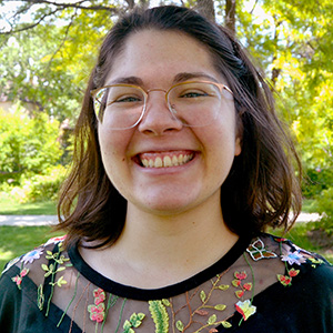 Delaine Anderson smiling while wearing a black blouse outside.