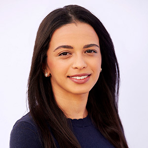 Alexandria Kristensen-Cabrera smiling while wearing a black shirt in front of a white background.