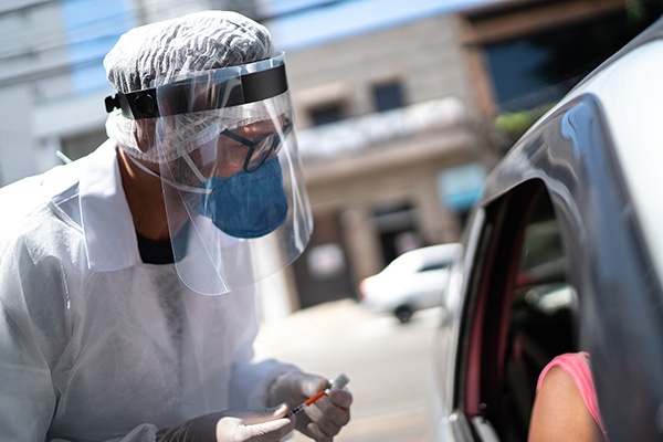 hp-small-feature-workforce Healthcare working in personal protective gear talking to someone in car
