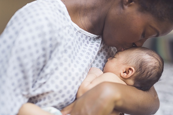 mother kissing small baby
