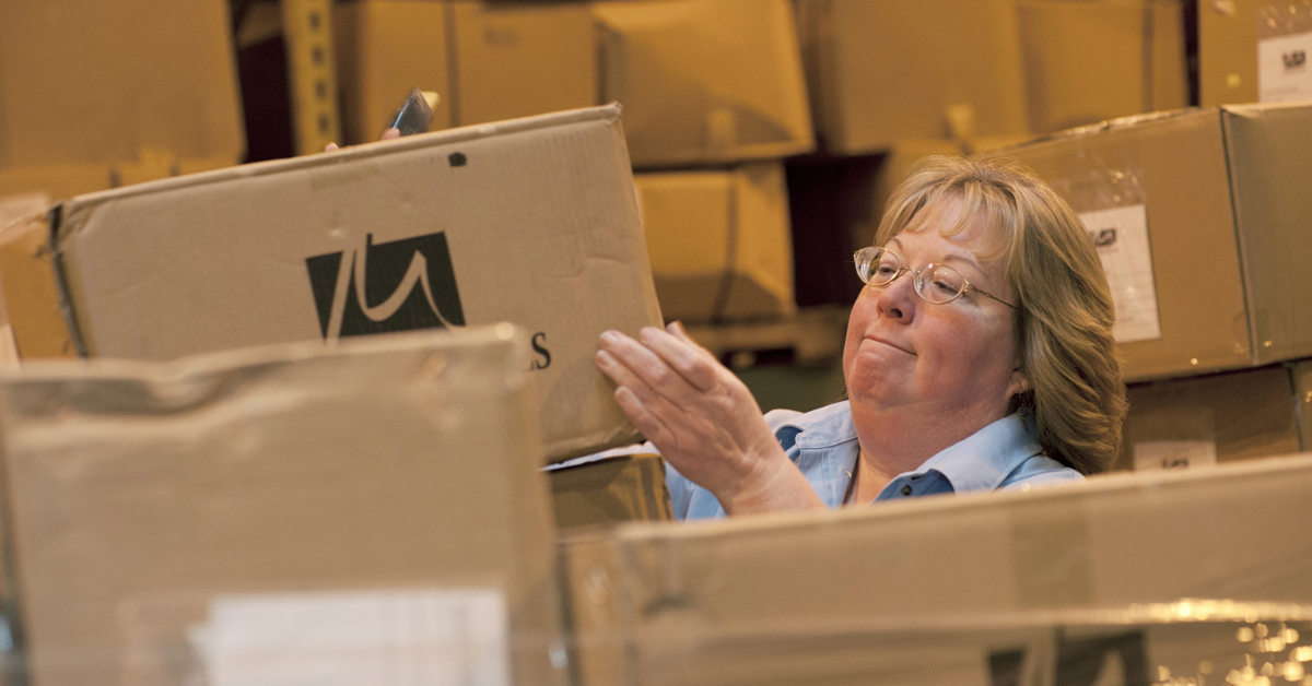 A worker inspects boxes of linens.