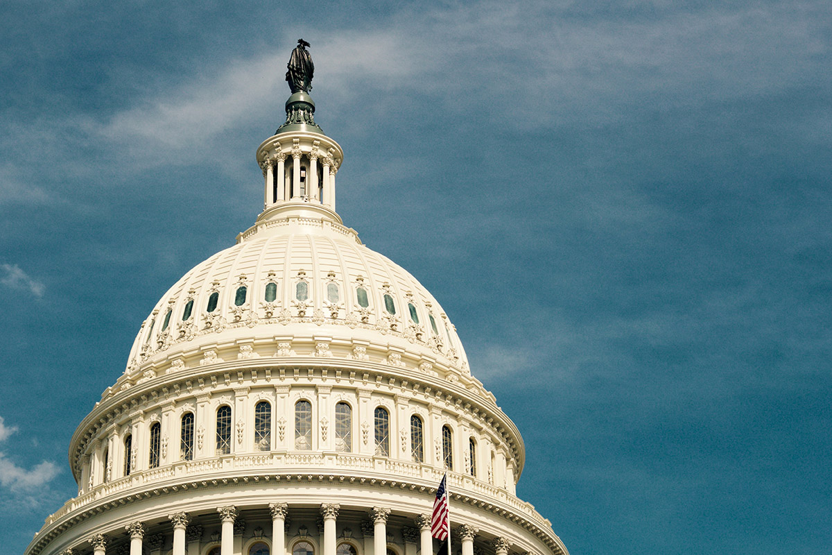 A view of the U.S. Capitol building against a blue sky.