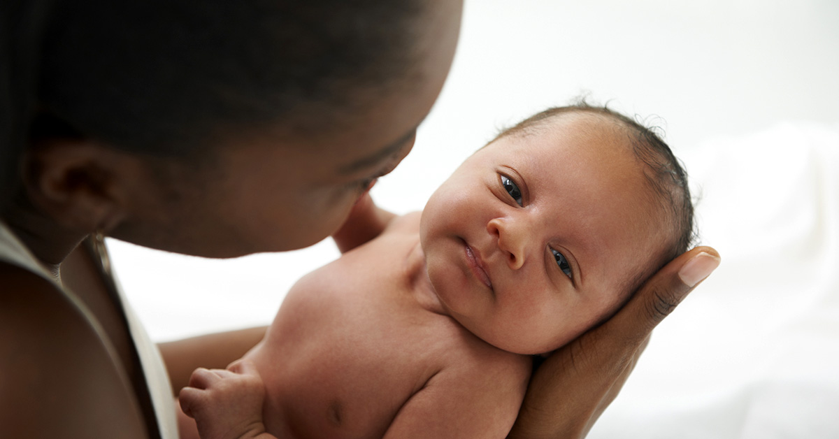 Close up of mother cradling newborn son