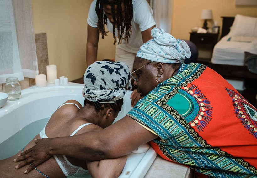 woman of color giving birth in a tub