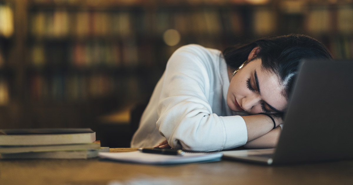 A student sleeping in a library