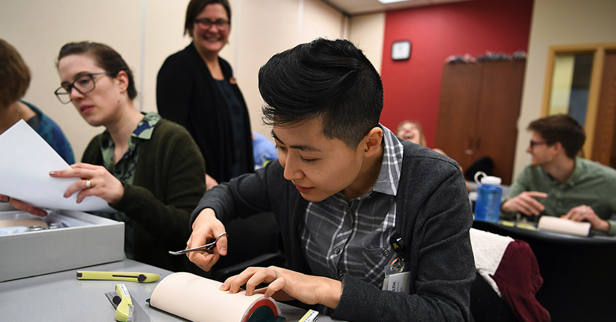 A medical student practices making stitches.