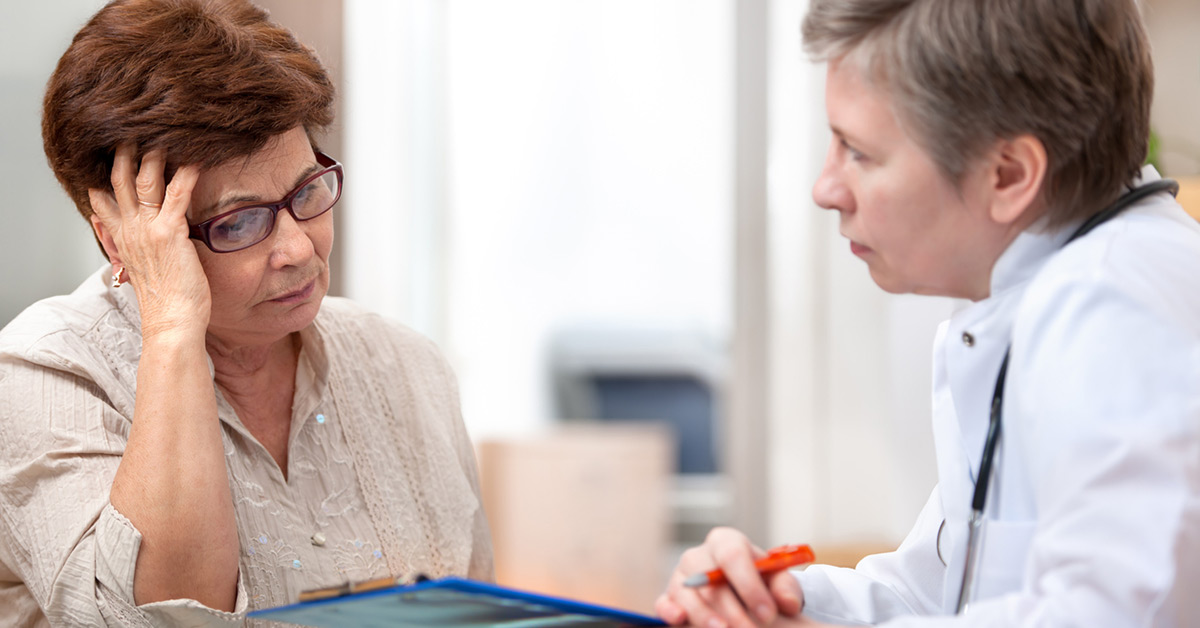 An older woman talks with a doctor.