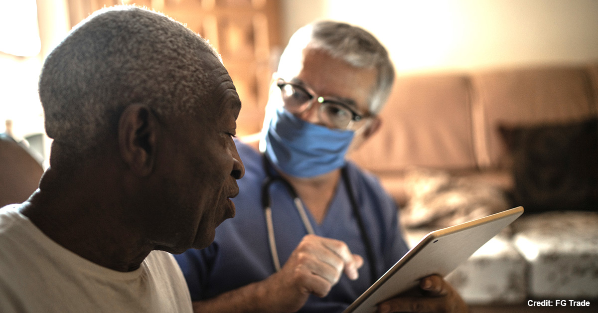 A nurse talks to a Black resident.