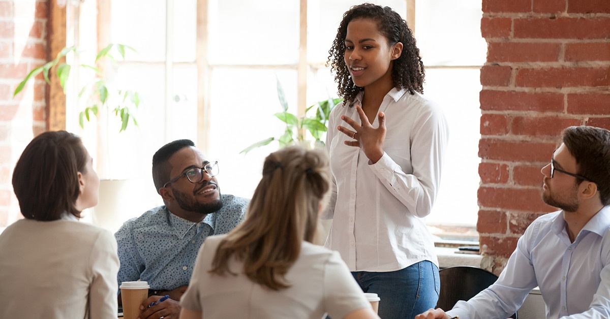 Co-workers sit around a table during a meeting.