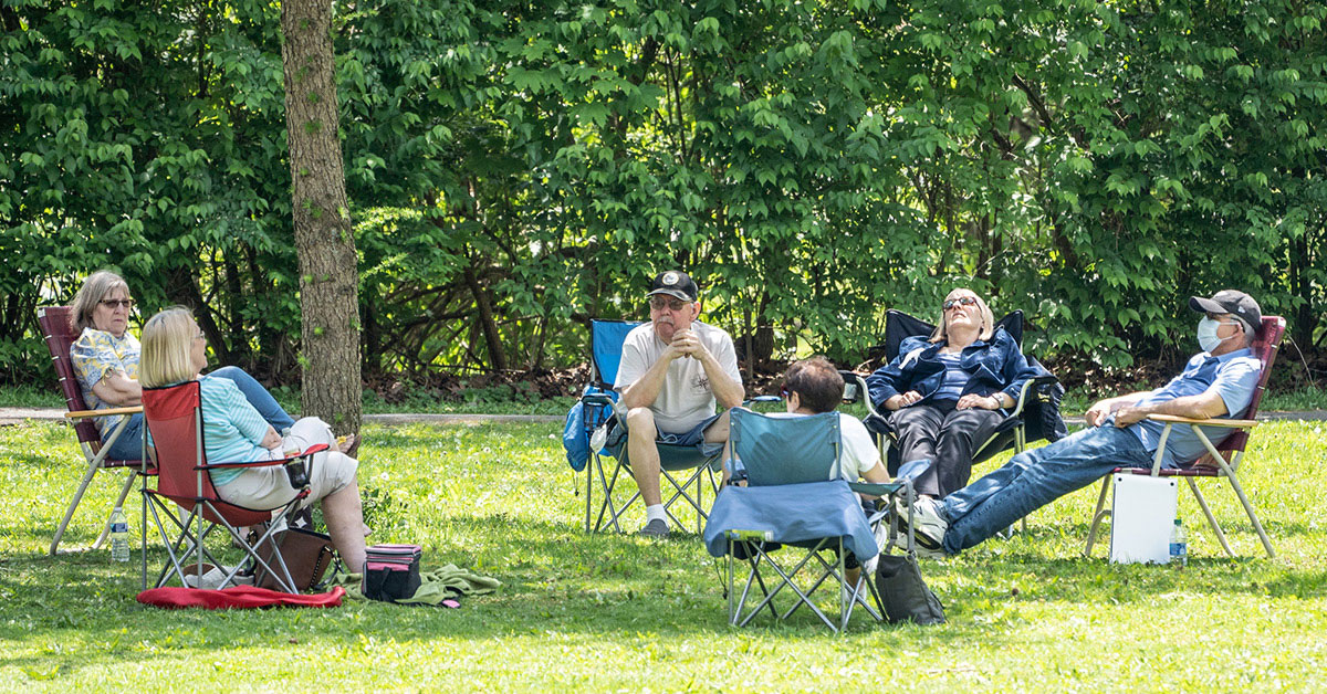 a group of people sitting in chairs outside.