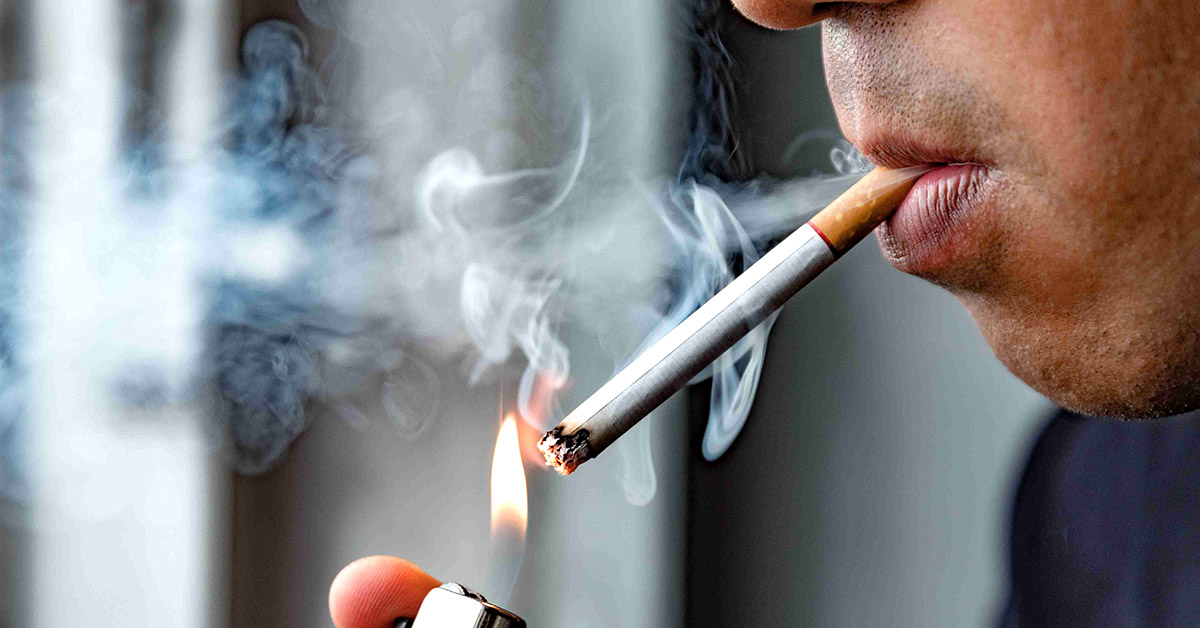 A man lights a cigarette.