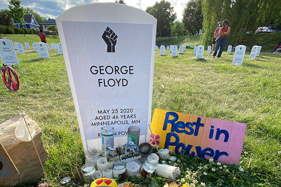 mock tombstone for george floyd with flowers
