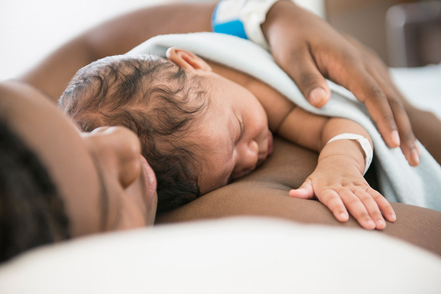 black mom with newborn baby on her chest