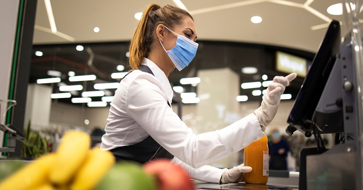 A grocery store worker rings up purchases.