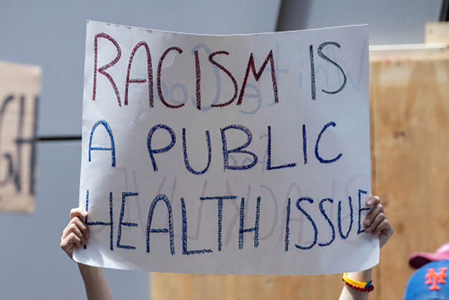 protest sign that reads: racism is a public health issue