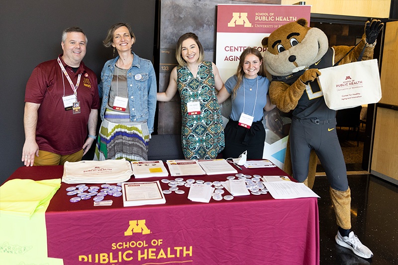 Staff pose with Goldy the Gopher at the Center for Healthy Aging and Innovation's exhibit booth.