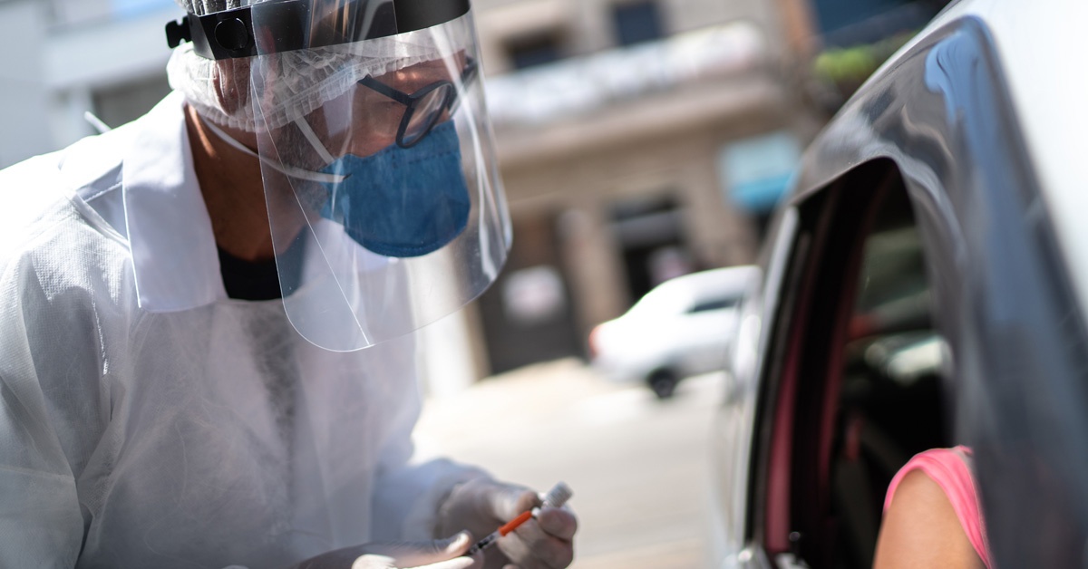 person giving someone else a vaccine in car