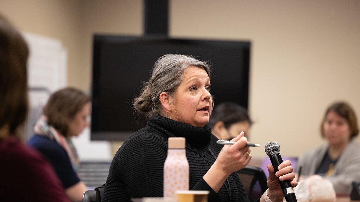 An educator from st paul public schools speaks with a mircophone in her hand.