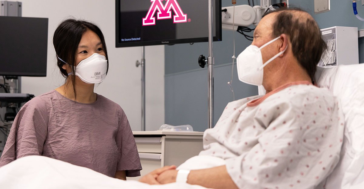 A student works with a patient in the hospital simulation room.
