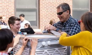 Students and faculty work with duct tape and air filters to create a Corsi-Rosenthal box