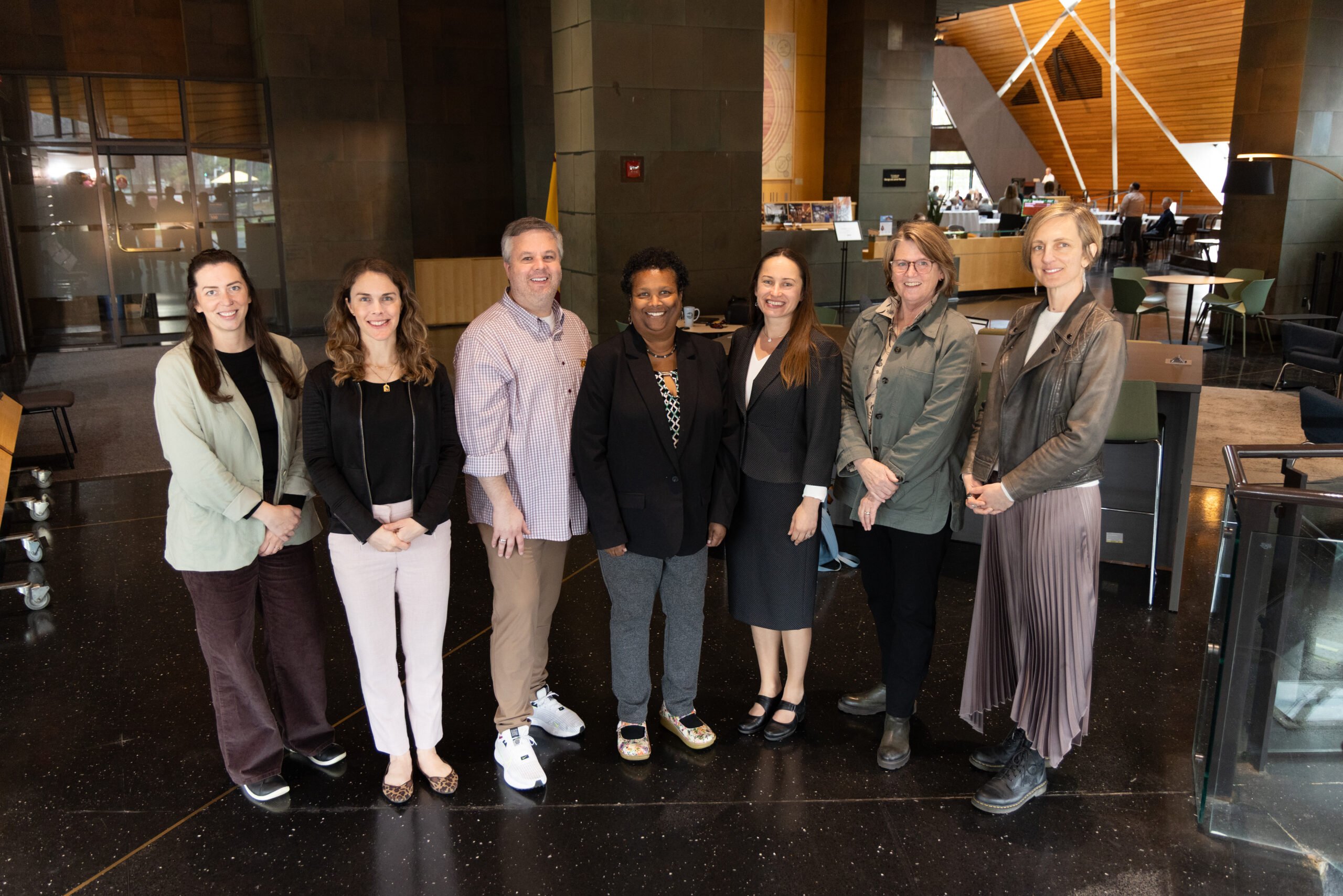 CHAIteam-MGS2025 Group photo of eight CHAI Leadership Team members standing together at the 2024 Minnesota Gerontological Society Annual Conference. From left to right: Allycia Wolff, Marti DeLiema, Rajean Moone, Robbin Fraizer, Tetyana Shippee, Siobhan, McMahon, Elma Johnson