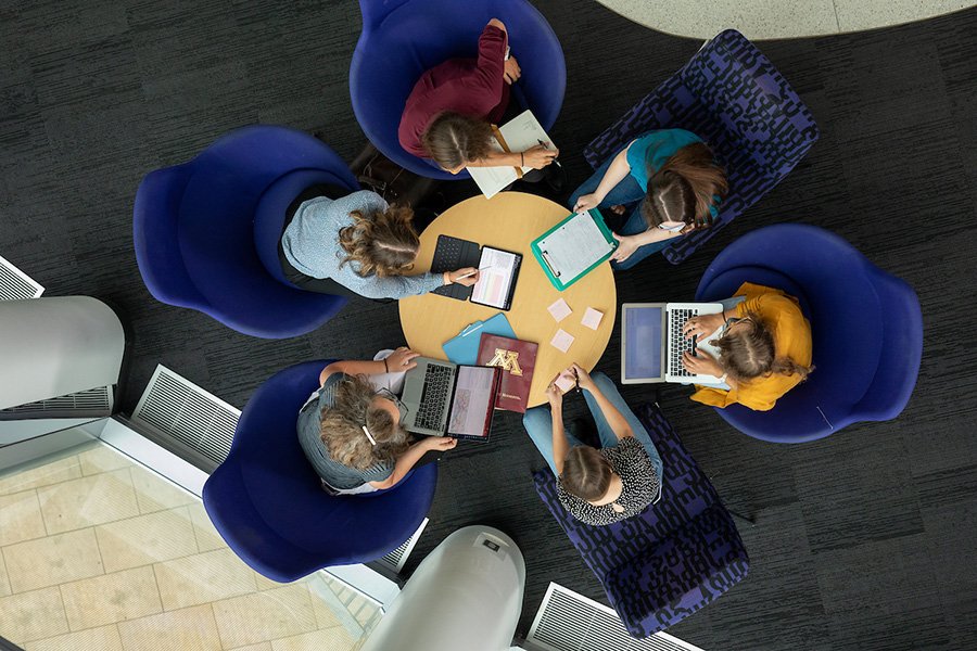 top down view of students collaboratively working at a small round table