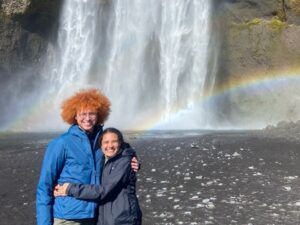 SPH student Zidane (right) with their partner Holden at a waterfall in Iceland