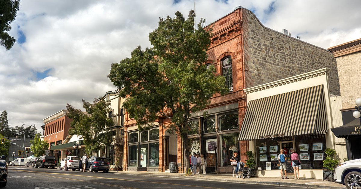 Small town main street with people walking in front of old brick buildings
