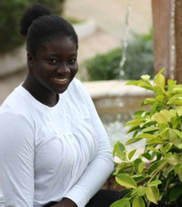 Love Odetola smiling next to a plant