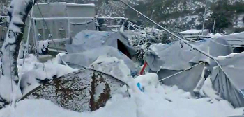 tents covered in snow inside a fenced area